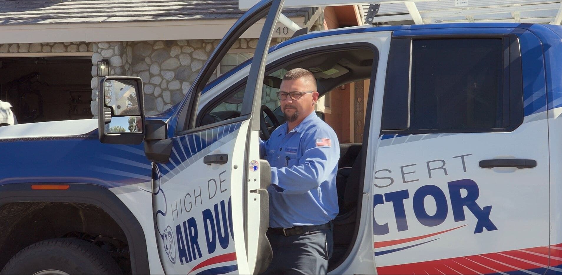 High Desert Air Duct technician standing beside a branded service van