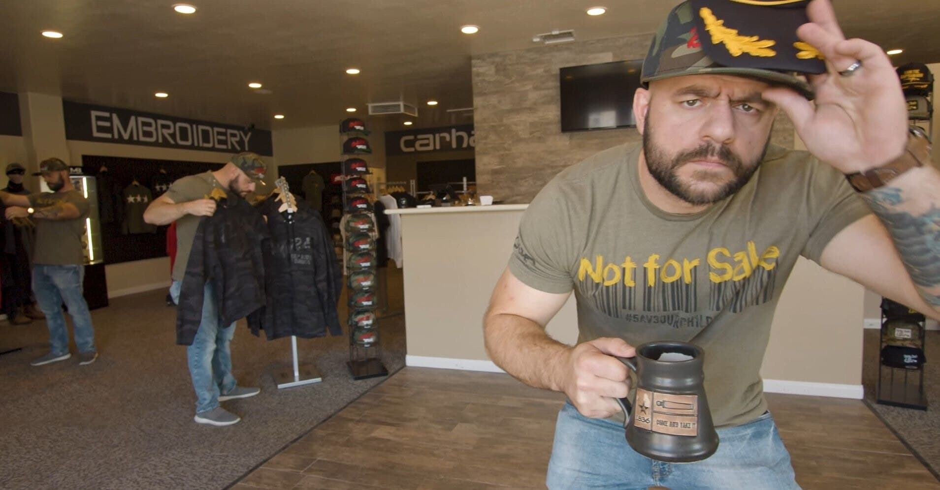 Man holding a coffee mug inside the SquarePrint shop